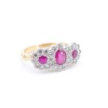 A fine triple daisy ruby and diamond ring, comprising a central oval ruby of approx 0.5 ct