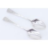 A pair of early Georgian silver table spoons, their stems having bright cut decoration and