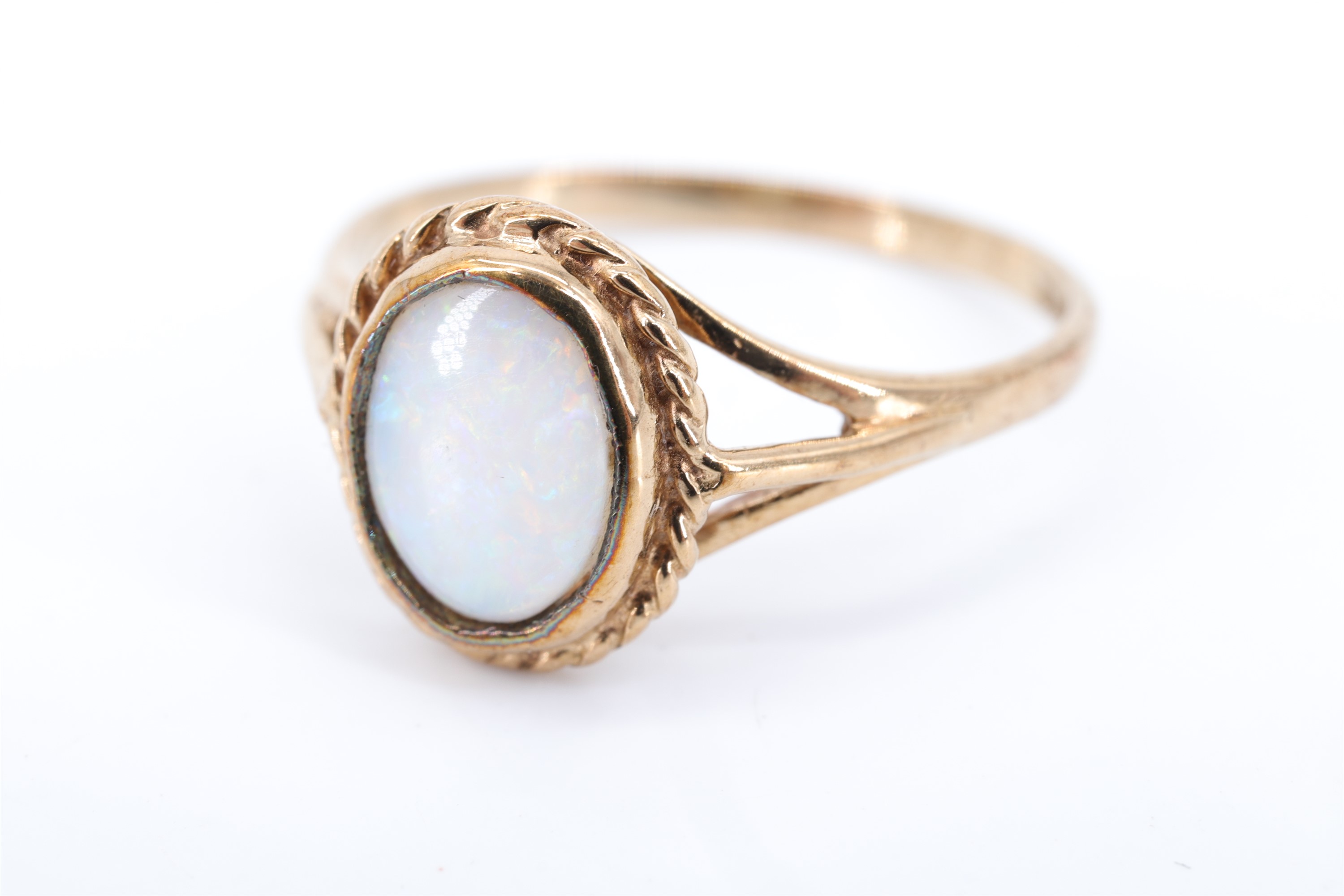 A lady's opal and 9 ct gold finger ring, having an oval opal in a rubbed over setting within a