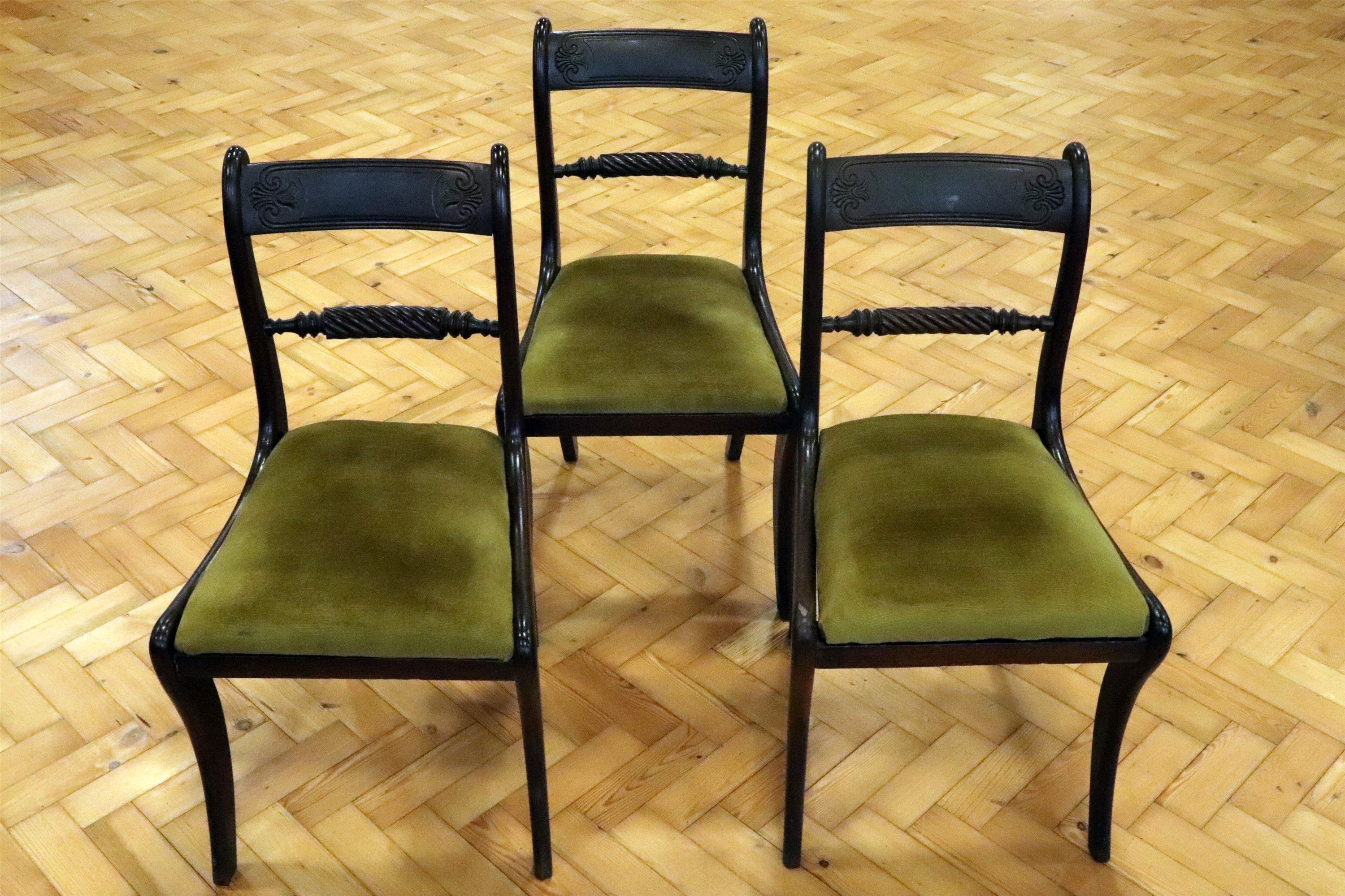 Three Regency mahogany sabre-legged dining chairs