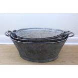 Three graduated galvanized baths, largest 83 x 30 cm