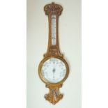 A late 19th / early 20th Century carved oak banjo aneroid barometer, 85 cm