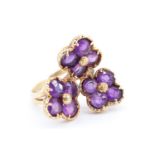 An uncommonly pretty amethyst triple flowerhead ring, comprising quatrefoil settings of round-cut