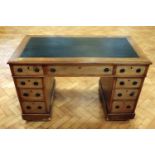 A Victorian mahogany pedestal desk, having an inset leathercloth top and brass ring handles, 120