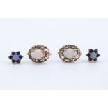 A pair of opal stud earrings, each 7 x 5 mm oval opal set on a frame of adorsed scrolls, with 9 ct