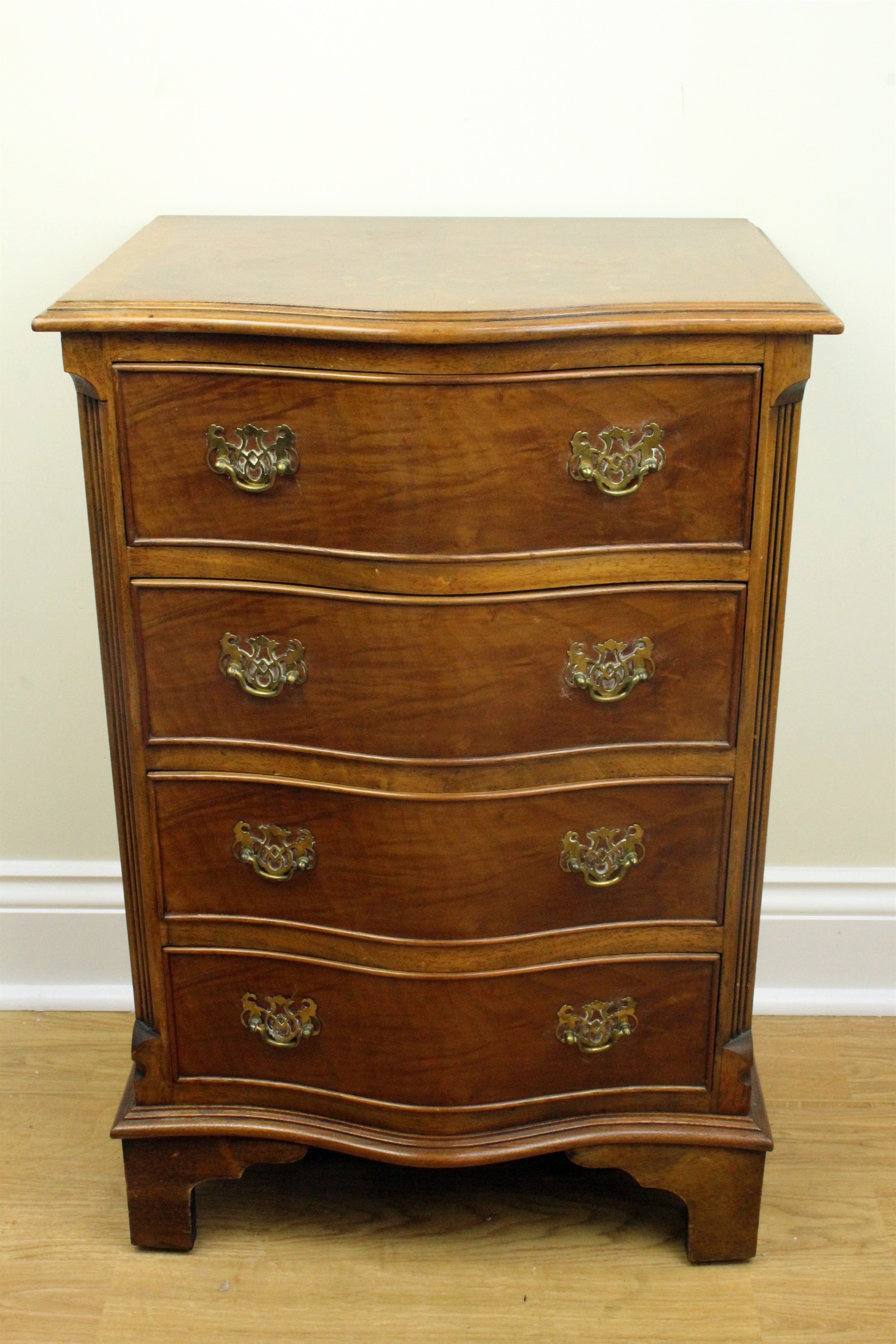 A late 20th Century diminutive reproduction Georgian mahogany serpentine-fronted chest of drawers,