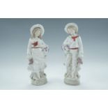 A pair of late 19th / early 20th Century German figurines of children holding grapes, 25 cm