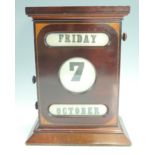 An Edwardian Sheraton revival mahogany desk calendar, the case having inlaid marquetry spandrels