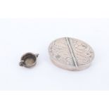 An oval-section silver two-compartment pill box together with a small white metal charm in the