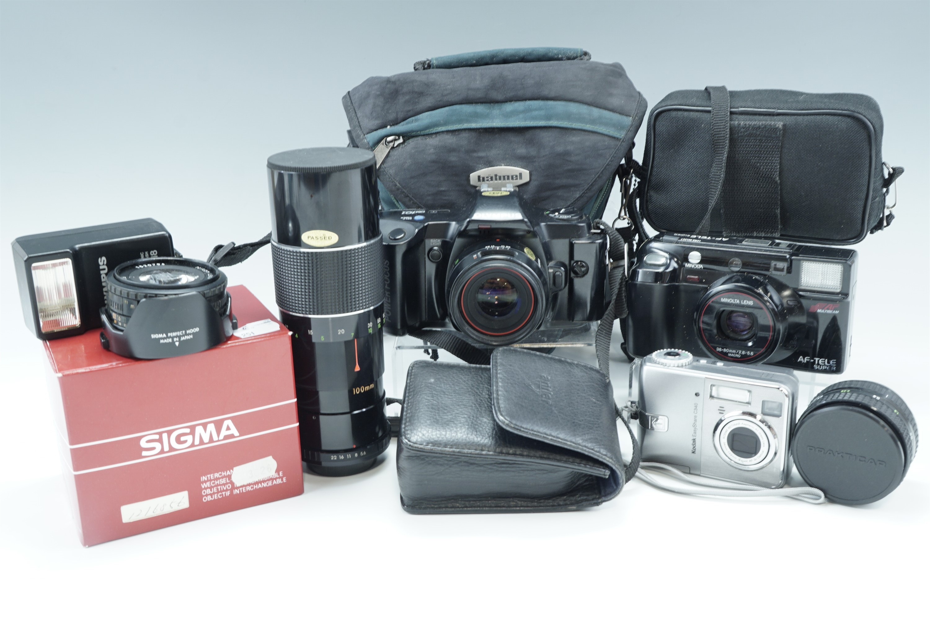 An Olympus OM 101 camera and flashgun, a Kodak Easyshare C340 camera, a Minolta AF-tele super