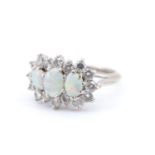 A 1970s diamond and opal dress ring, the central 6 x 5 mm opal line set between two smaller opals,