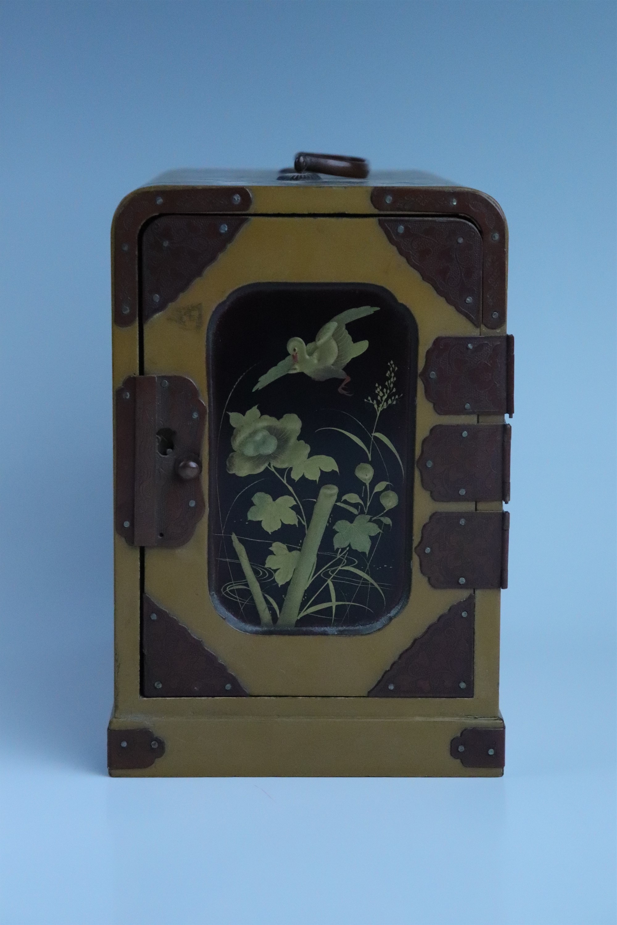 An early 20th Century Japanese lacquered ko dansu table cabinet, its door taka maki-e decorated in