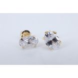 A modern pair of white garnet stud earrings, the oval cut stones 5 x 7 mm in a four claw setting