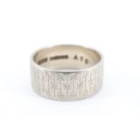 A 1960s 9 ct white gold broad wedding band, decorated in a pattern of engraved stars, N, 5.3 g