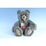 A late 20th Century plush Teddy bear by Teddy-Hermann, having articulated joints and glass eyes,