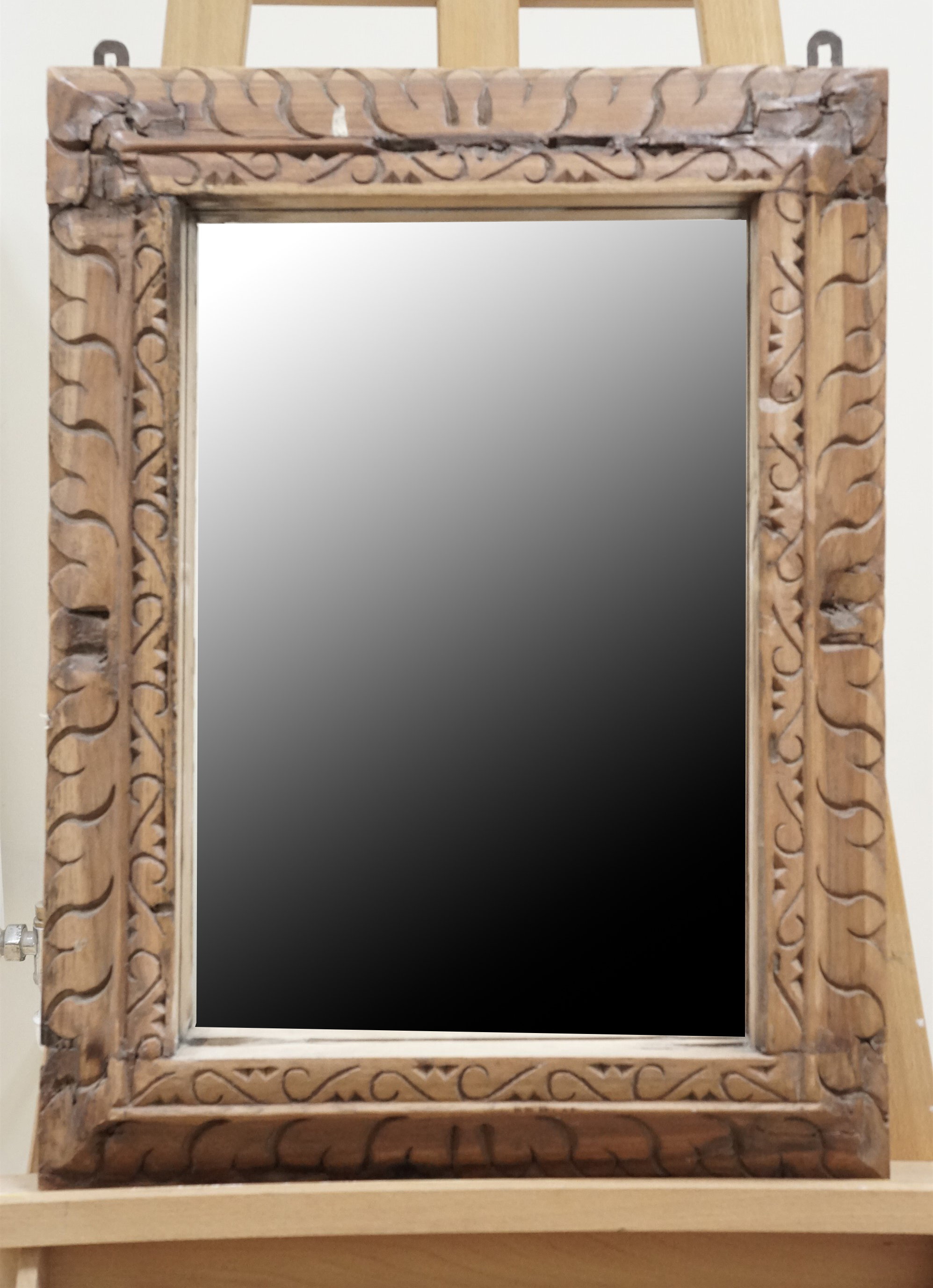 A wall mirror in heavy carved wood frame, 63 cm x 46 cm