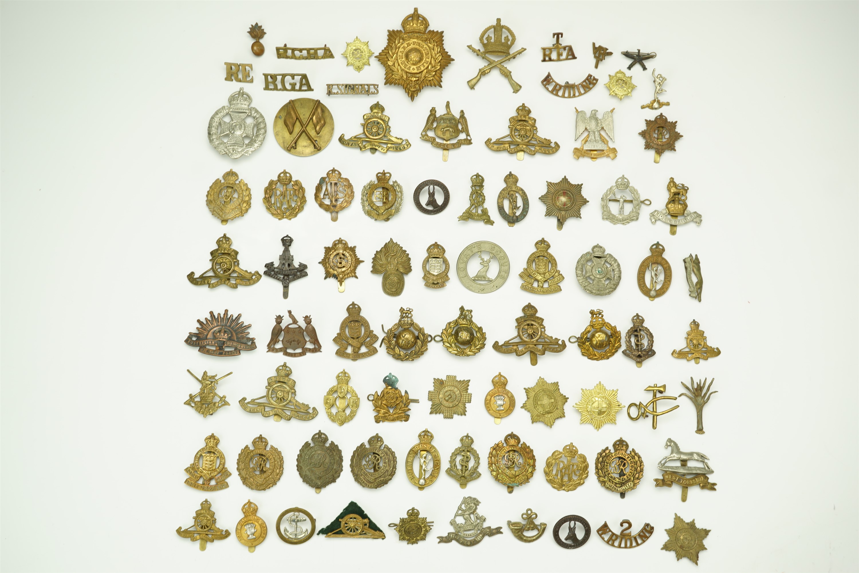 A large collection of cap, collar and shoulder badges together with brass shoulder titles and