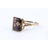 A 20th Century lady's late smoky quartz ring, having a square cut stone (10 x 12 mm) in a four prong