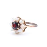 A late 20th Century lady's daisy set almandine and opal ring, the central 6 mm brilliant garnet