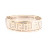 A 9 ct yellow metal gold hinged cuff bangle, shallow relief decorated in a Greek key pattern, 6 cm x