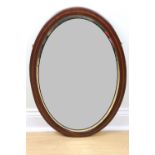 An early 20th Century oval bevel-edged wall mirror in string-inlaid mahogany frame, 74 cm x 49 cm