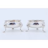 A pair of George II gilt silver salt cellars, each being of compressed ovoid form on three legs