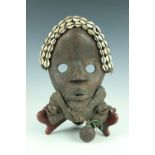 An African carved wooden mask, Dan people, Ivory Coast, decorated with cowrie shells and bells, 29