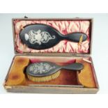 A cased early 20th Century ebony and silver dressing table set, compromising brush, comb and hand
