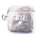 An Edwardian silver fob vesta case of contoured square cushion form decorated with foliate scroll