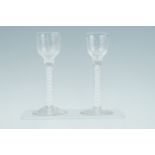 A pair of George III wine glasses, each having a ribbed bowl, double opaque and spiral gauze tube