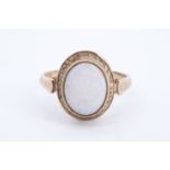 An oval opal cabochon ring, the stone of approx 10 mm x 8 mm bezel set between the fluted
