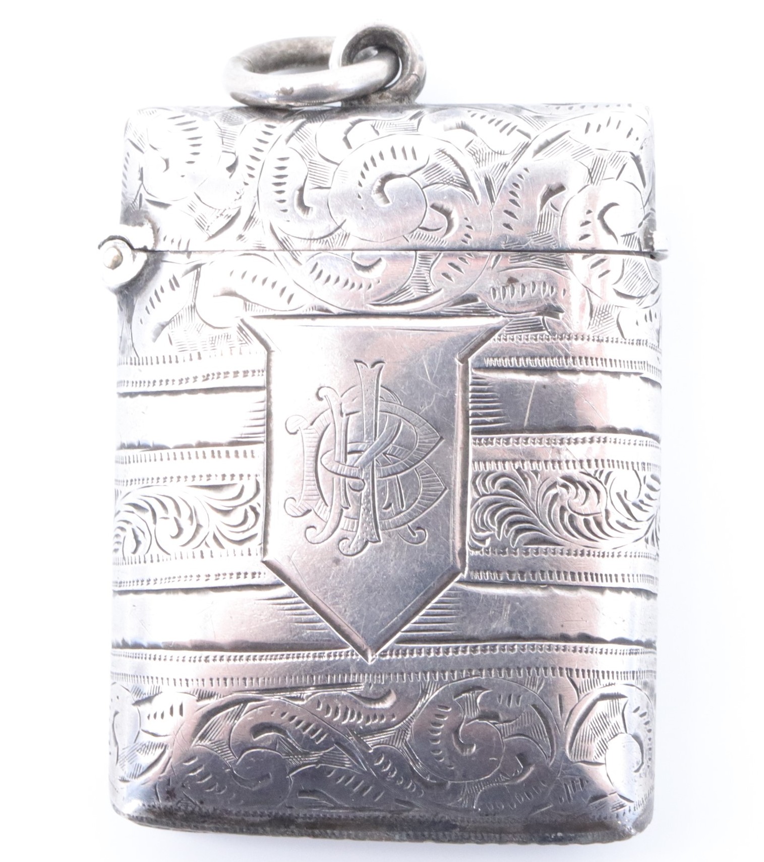 A late Victorian silver fob vesta case, of cushion form bearing banded foliate scroll engraved