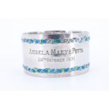 A 1930s Liberty & Co Arts and Crafts enamelled silver napkin ring, having a planished finish with