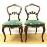 A pair of Victorian carved and upholstered walnut fancy balloon back salon / dining chairs