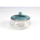 An Art Deco enamelled silver and cut glass powder pot, having a green guilloche enamelled cover with
