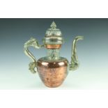 A Tibetan tea pot, with hand raised copper body having nickel alloy and embossed brass elements,