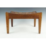 An oak arts and crafts stool by Arthur R Simpson of Kendal with leather strap top, bearing his "