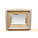 A bevel-edged wall mirror in ornate gilt frame, 67 cm x 56 cm