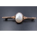 A late 19th / early 20th Century 9 ct yellow metal and mabe pearl bar brooch, the blister pearl