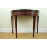 A George III Sheraton style inlaid mahogany half-moon games table, its top segmentally veneered,