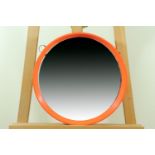 A 1970s orange plastic framed circular wall mirror, diameter 39 cm