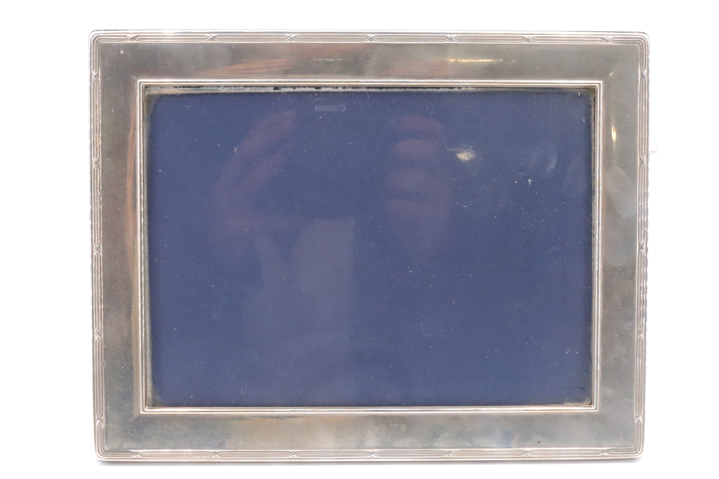 A modern silver fronted photograph frame, having ribbon and reed decoration and lightly engraved '