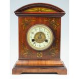 An early 20th Century German walnut mantle clock, having a brass movement striking on a gong, the