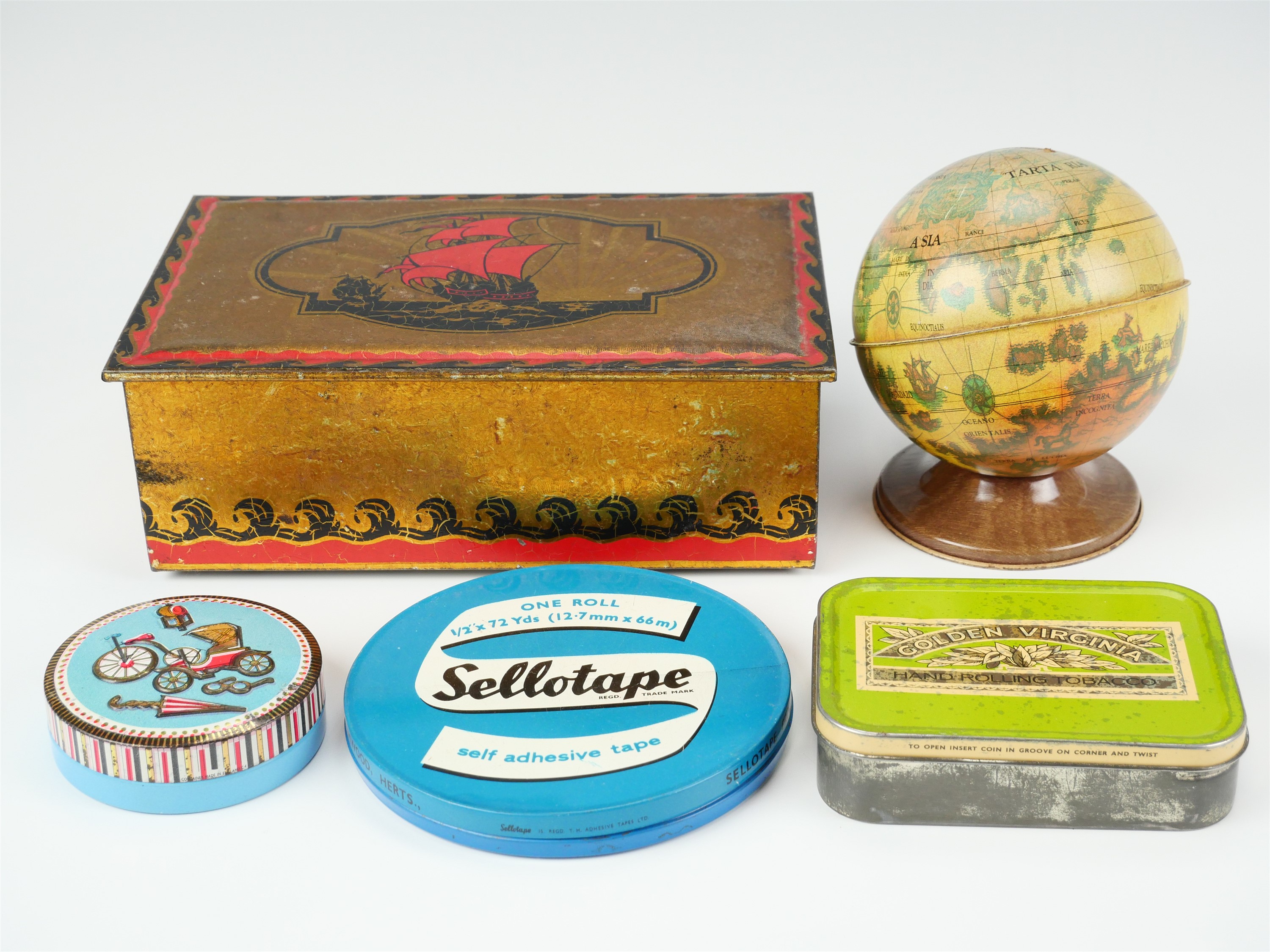 A tinplate money box in the form of a terrestrial globe, together with four printed tinplate