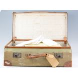 An early 20th Century canvas and hide bound suitcase containing a quantity of Victorian and early