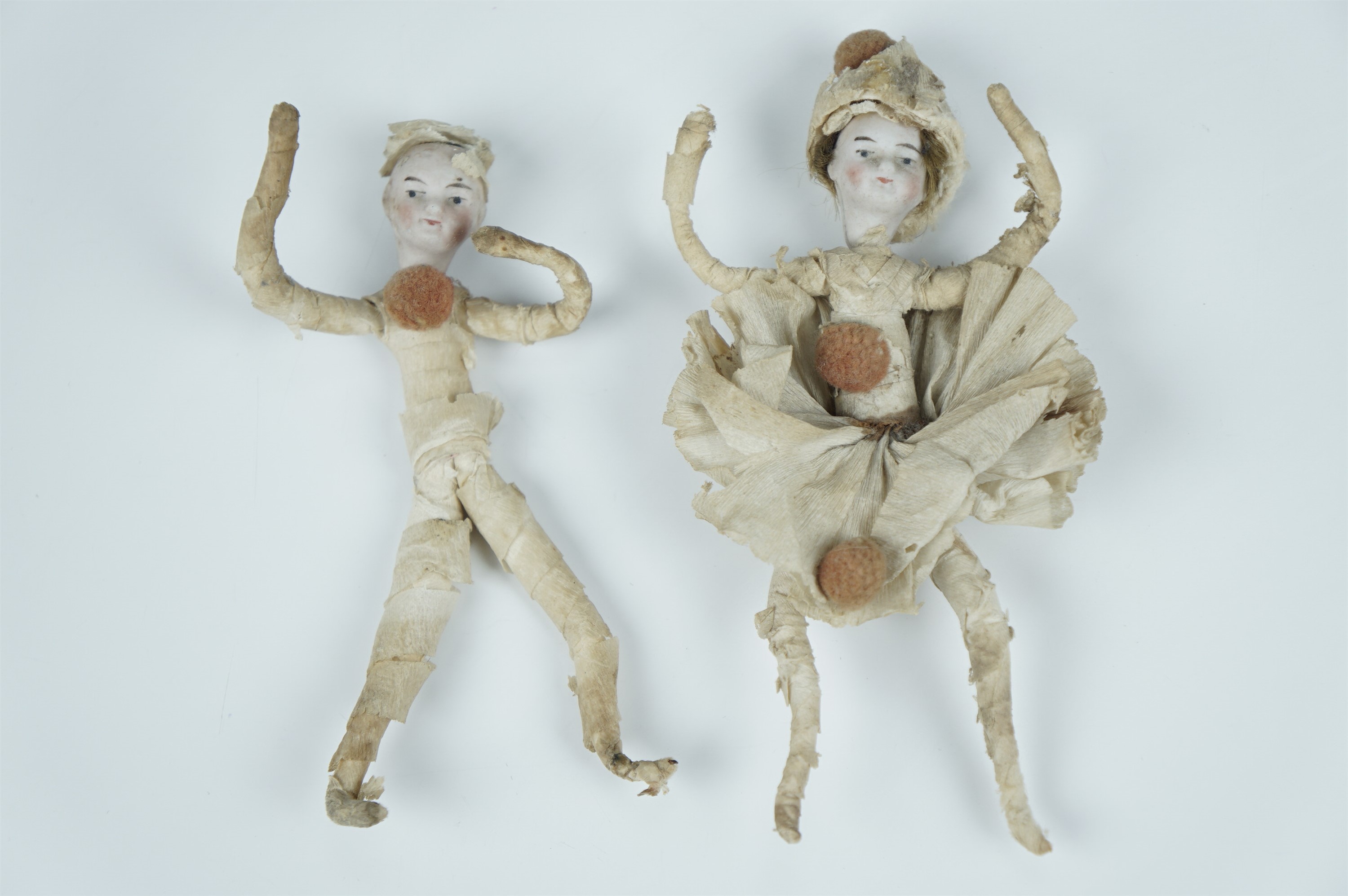 A pair of vintage German Christmas cracker dolls, each having a bisque head and wire armature