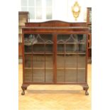 A George V astragal glazed mahogany display cabinet, having a gadrooned top and standing on short