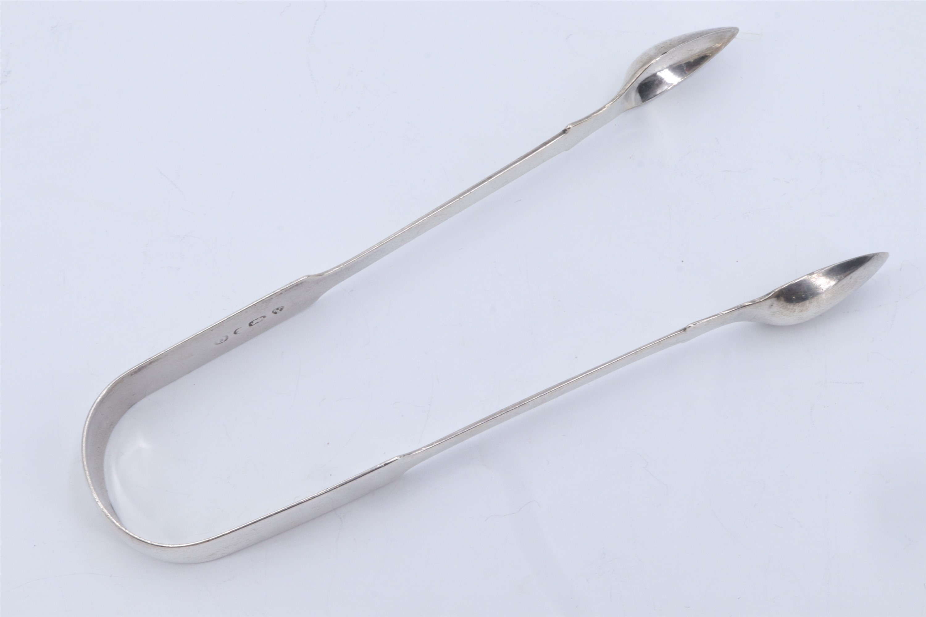 A pair of George IV silver fiddle pattern sugar tongs, the bow bearing an engraved 'E', Newcastle,