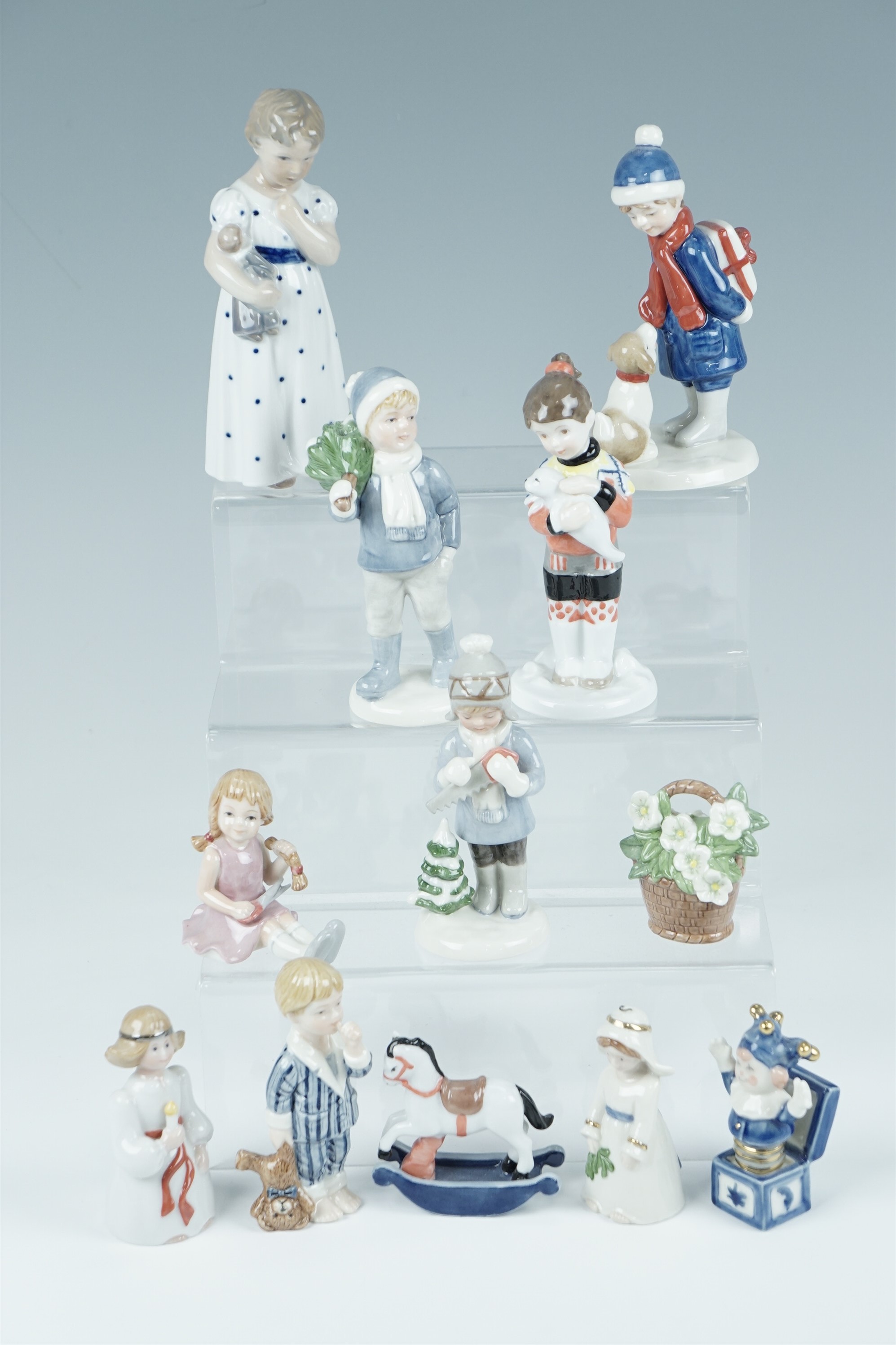 Twelve Royal Copenhagen figurines including boy with puppy, rocking horse etc