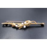 A 9 ct gold and seed pearl bar brooch, the bar faced with a pearl-set fruiting sprig, in period